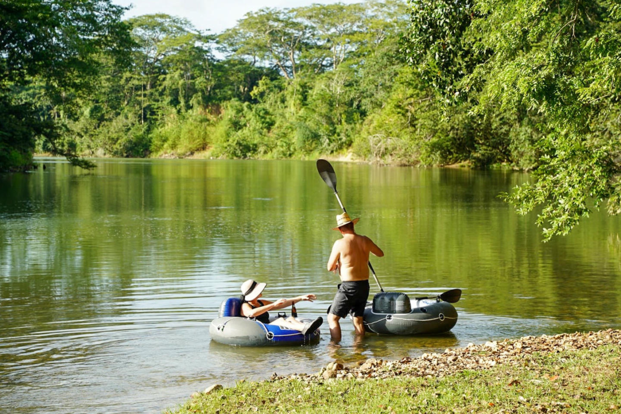 Couple paddleboarding at the Belize River next to Carmelita Gardens, in Santa Familia, Cayo District, Belize. Couple paddleboarding at the Belize River next to Carmelita Gardens, in Santa Familia, Cayo District, Belize.