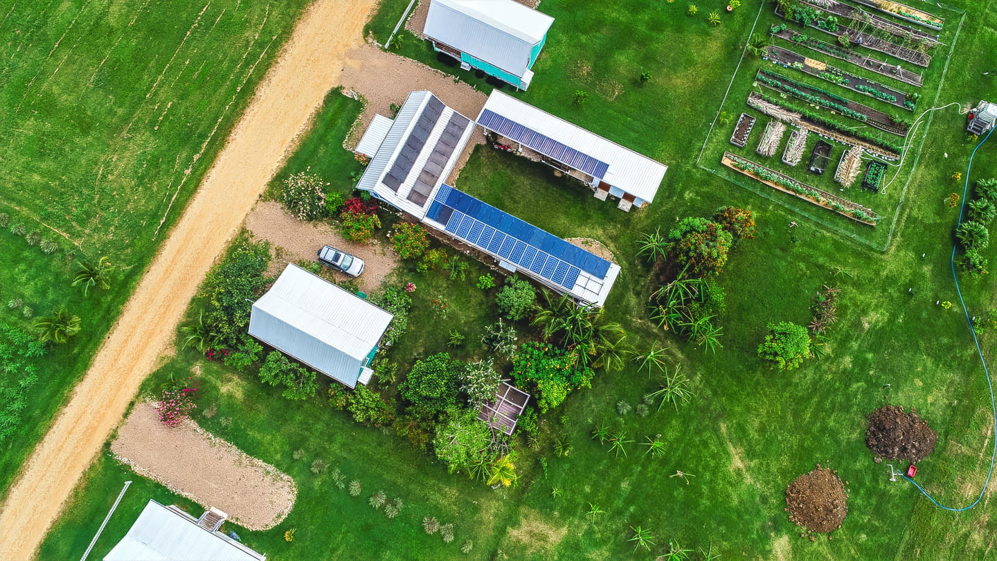 Aerial view of solar panel homes at Carmelita Gardens, in Santa Familia, Cayo District, Belize. Click for more information.