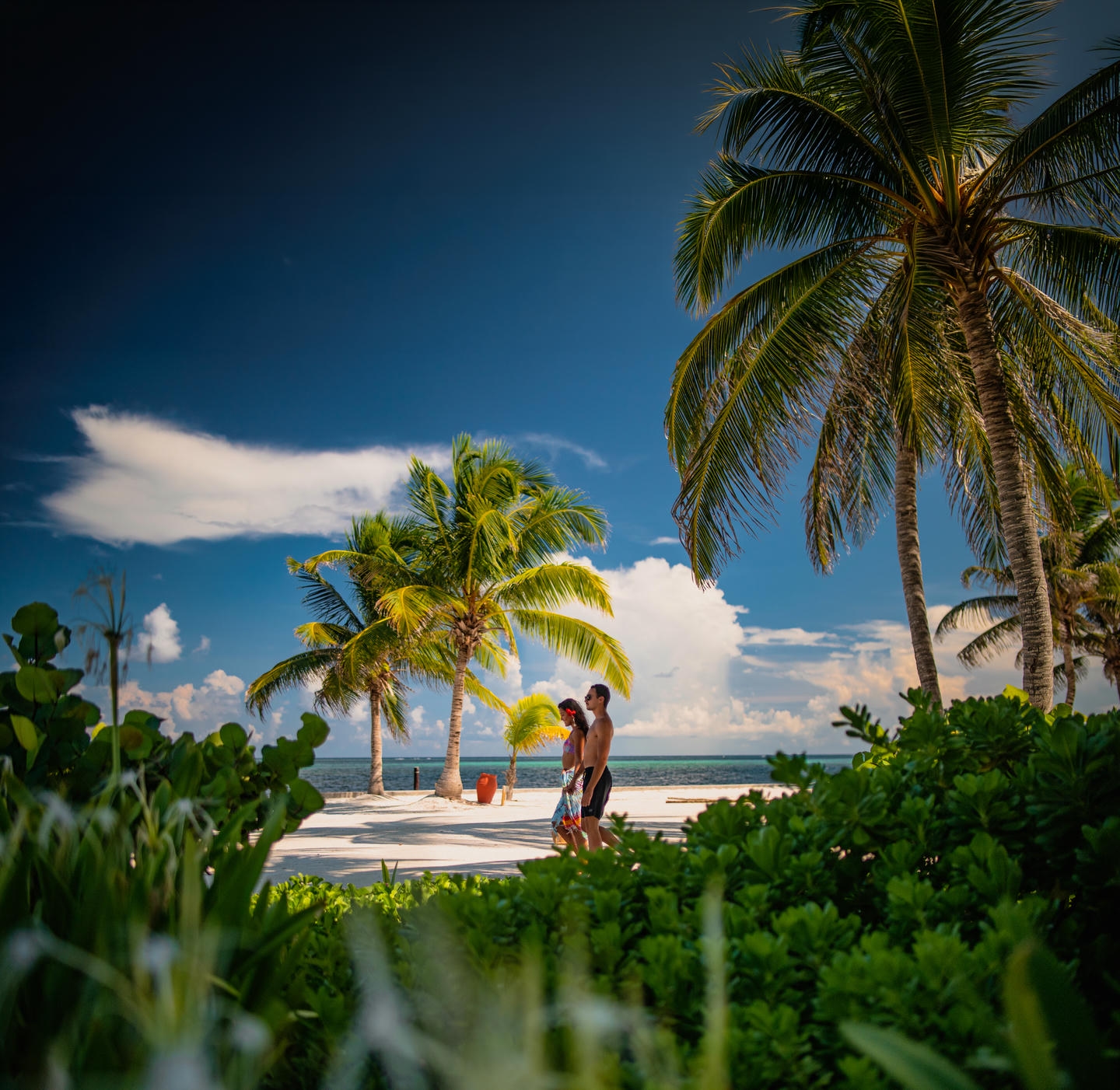 Couple walking down beach in Ambergris Caye, Belize. Couple walking down beach in Ambergris Caye, Belize.